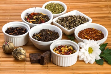Aromatic Dried Tea Leaves in Bowls on Bamboo Mat
