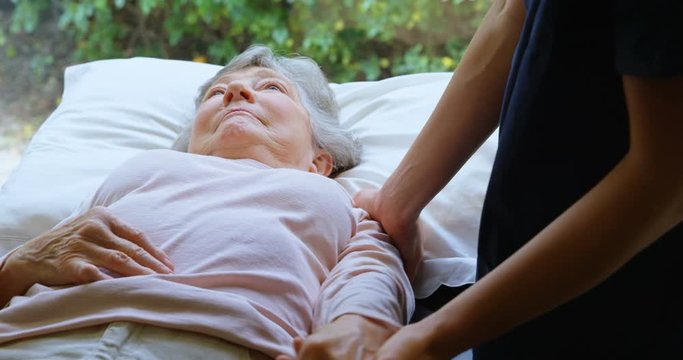 Physiotherapist giving shoulder therapy to senior woman 4k