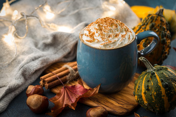 Pumpkin latte with spices and whipped cream on top on a wooden background. Copy space. Autumn or winter hot drink.
