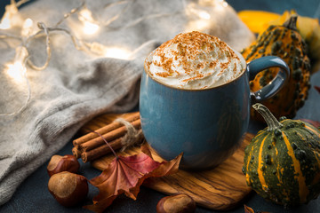 Pumpkin latte with spices and whipped cream on top on a wooden background. Copy space. Autumn or...