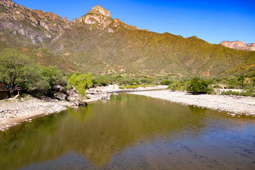 The calm Urique river, near the town of Urique at the base of the Urique Canyon, part of the Copper Canyon system in Chihuahua state, Mexico - obrazy, fototapety, plakaty