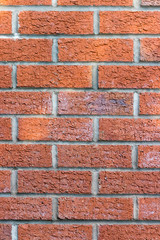 Obraz premium Old red brick wall in sunlight, seamless background photo texture – portrait mode, vertical orientation