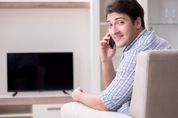 Young man watching tv at home