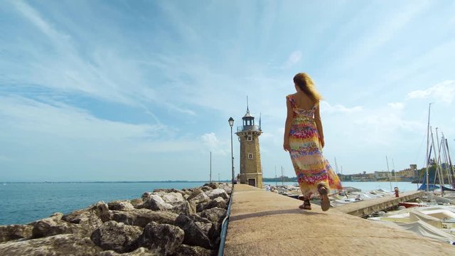 Beautiful girl goes to a lighthouse