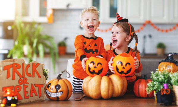 happy children in costumes of pumpkins are preparing home for  holiday Halloween.