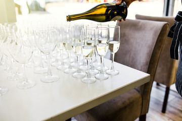 Elegant glasses with champagne standing in a row on serving tabl