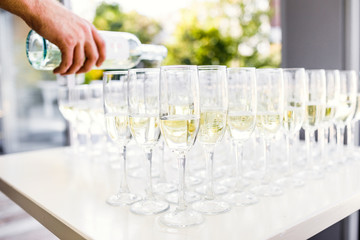 Elegant glasses with champagne standing in a row on serving tabl