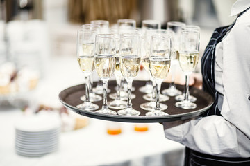 Elegant glasses with champagne standing in a row on serving tabl
