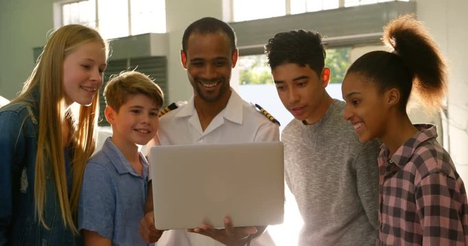 Male pilot training kids on laptop 4k