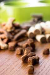 Dog tasty colored biscuits on wooden background, bowl