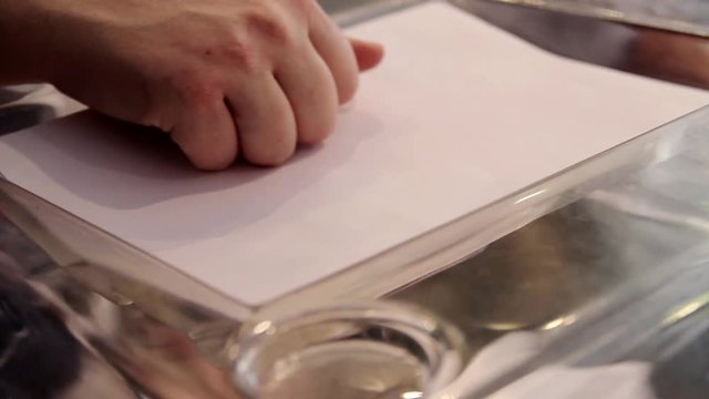A hand casts a vote in a ballot box during the elections in Athens, Greece