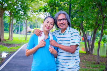 Portrait of happy. Happy Asian senior couple . They are big hug after Jogging in park. They are smiling and happy in good time , husband and wife, love , Photo concept Health and relax time.