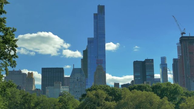 4K (UHD) 25P New Yor City, Central Park - Sheep Meadow trees and city skyline in the background