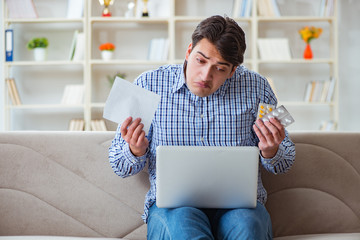 Young man sitting on the sofa with pills and prescription