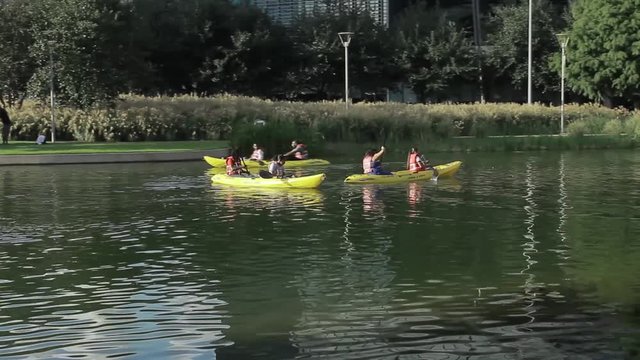 Some people kayaking in a small pond.