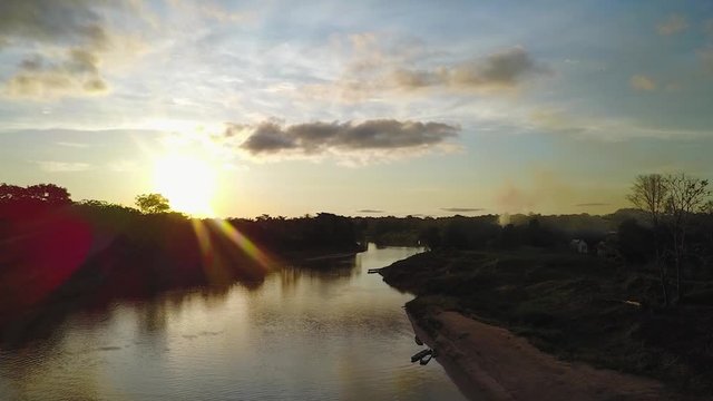 Aerial shot of sunset with clouds in a Brazillian village Nova Morada with a beautiful river