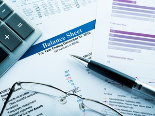 Obraz premium Calculator, Glasses And Pen On Balance Sheet Close-up