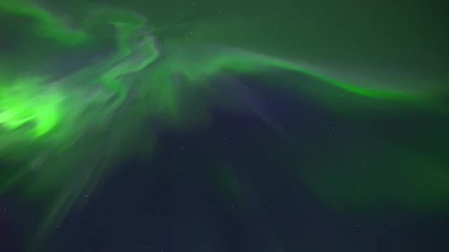 Northern Lights or Aurora Borealis -filmed in real time video in 4k resolution- dancing in a clear night skies. This is a rare case of so called corona with greens, purple and blue colours.
