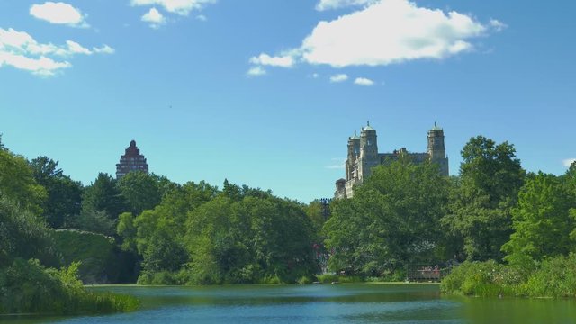 4K (UHD) 25P New Yor City, Central Park - Pond with trees and two buildings in the background