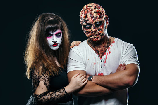 scary man with a face burn with a witch on a black background, zombie and a dead bride on a halloween carnival, couple with halloween makeup on black background, halloween face art, halloween concept