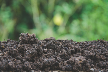 Preparing soil for agriculture and Pile of soil with green background.