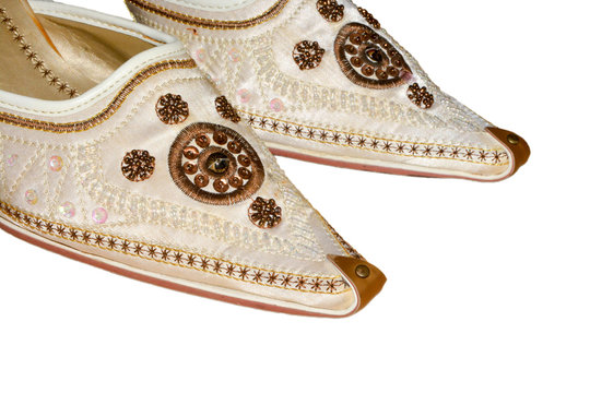 Arab women's white shoes made of natural silk embroidered with curled toes on isolated background.  