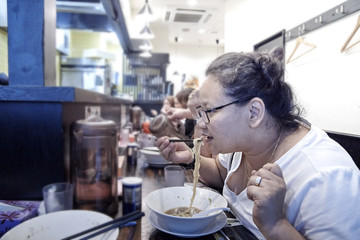 Fototapeta na wymiar Woman eating Japanese udon