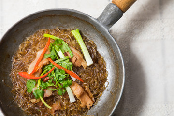 casserole becon with glass noodles in pan on white table