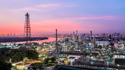 Fototapeta na wymiar Aerial view petrochemical industrial oil refinery at sunset with city background.