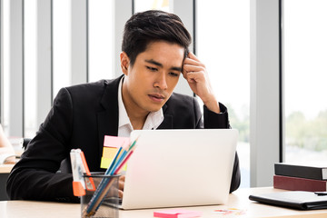 Asian Businessman is getting stress about work at the office.