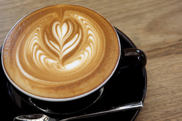 Hot coffee latte on a wooden table.