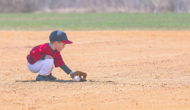 Child Fields a Ground Ball During a Baseball Game