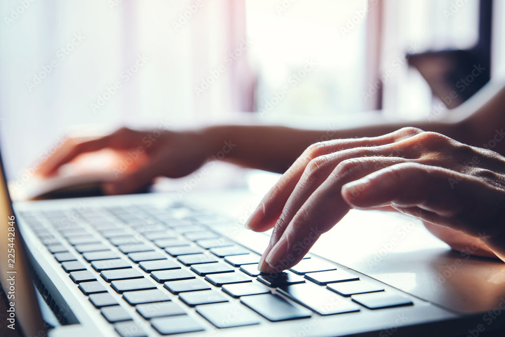 Poster close-up of a worker using a laptop computer.pressing buttons, typing, simple close up with lens fla