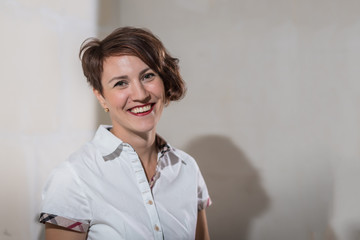 Cute young woman in white construction protection building helmet in unfinished apartment © keleny