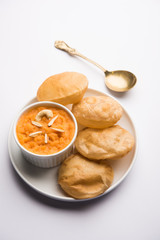 Suji/Sooji Halwa Puri or Shira Poori breakfast, served in a plate and bowl. selective focus