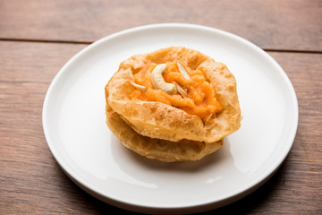Suji/Sooji Halwa Puri or Shira Poori breakfast, served in a plate and bowl. selective focus