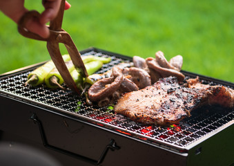 meat grilled in grilling basket on charcoal stove