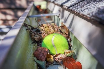 Tennis ball stuck in gutter on a roof