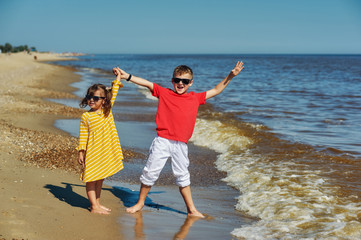 Cheerful children on the sea coast . Brother and sister on a walk
