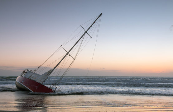 Sunken yacht on ocean shore