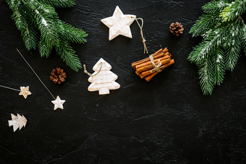 New year symbols. Spruce branch, cones and toys for decoration like spruce and stras on black background top view copy space