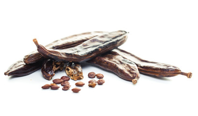 Carob pods and seeds on white background