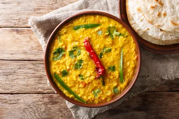 Foto op Plexiglas Indian popular food Dal Tadka Curry served with roti flatbread close-up. Horizontal top view © FomaA