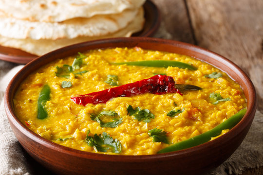 Daal Curry traditional Indian food made of yellow lentil with spices and herbs close up in a bowl. Horizontal