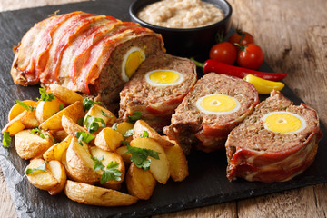 German meatloaf (Falscher Hase or Hackbraten) is a traditional pork and beef meat loaf bound with boiled eggs, a real hearty comfort food close-up. horizontal