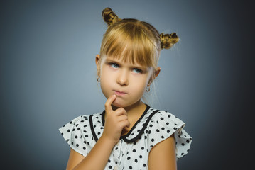 Closeup Thoughtful girl with Hand at head isolated on Gray