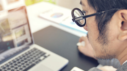 Asian business man wearing eyeglass in office.