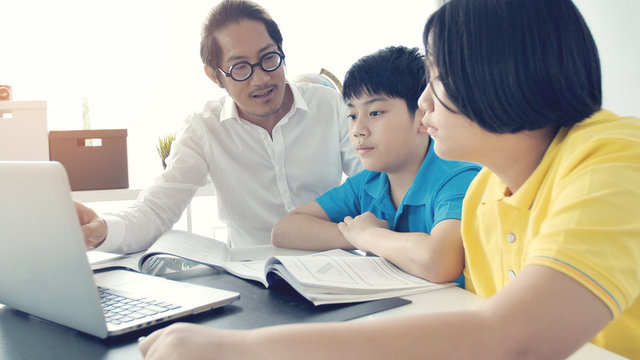 Asian child learning with teacher at home.