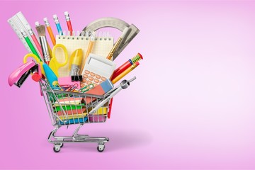 Stationery objects in mini supermarket cart on