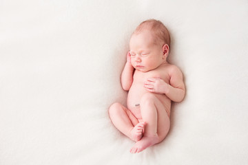 Funny newborn baby sleeping peacefully naked. Top view - obrazy, fototapety, plakaty